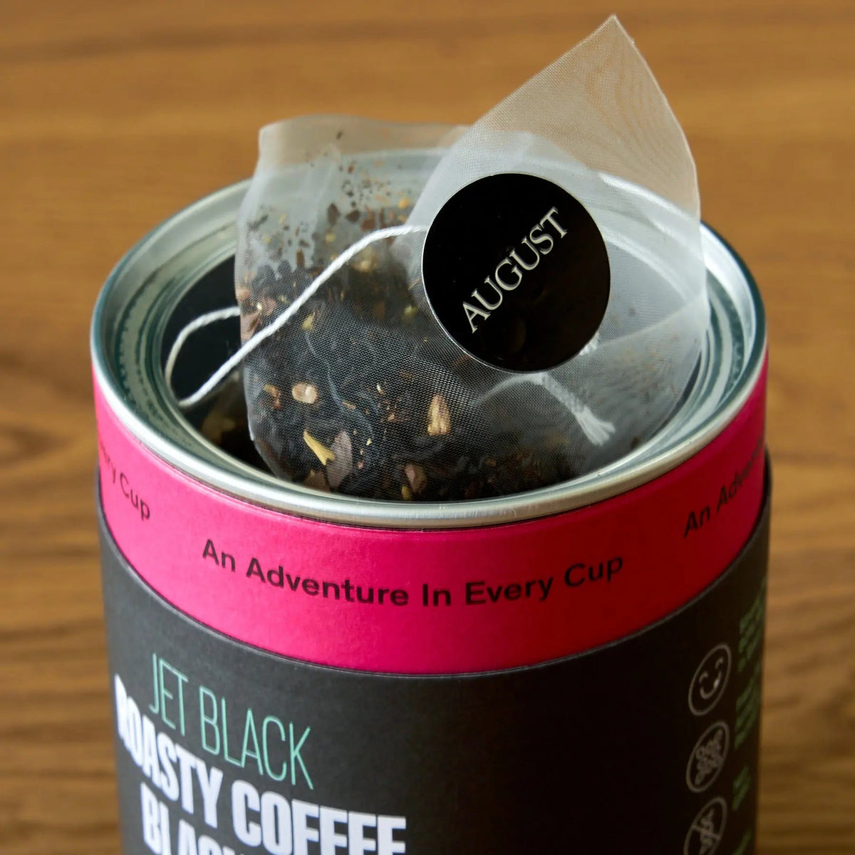 Pyramid tea bag resting inside the open black tea tin.