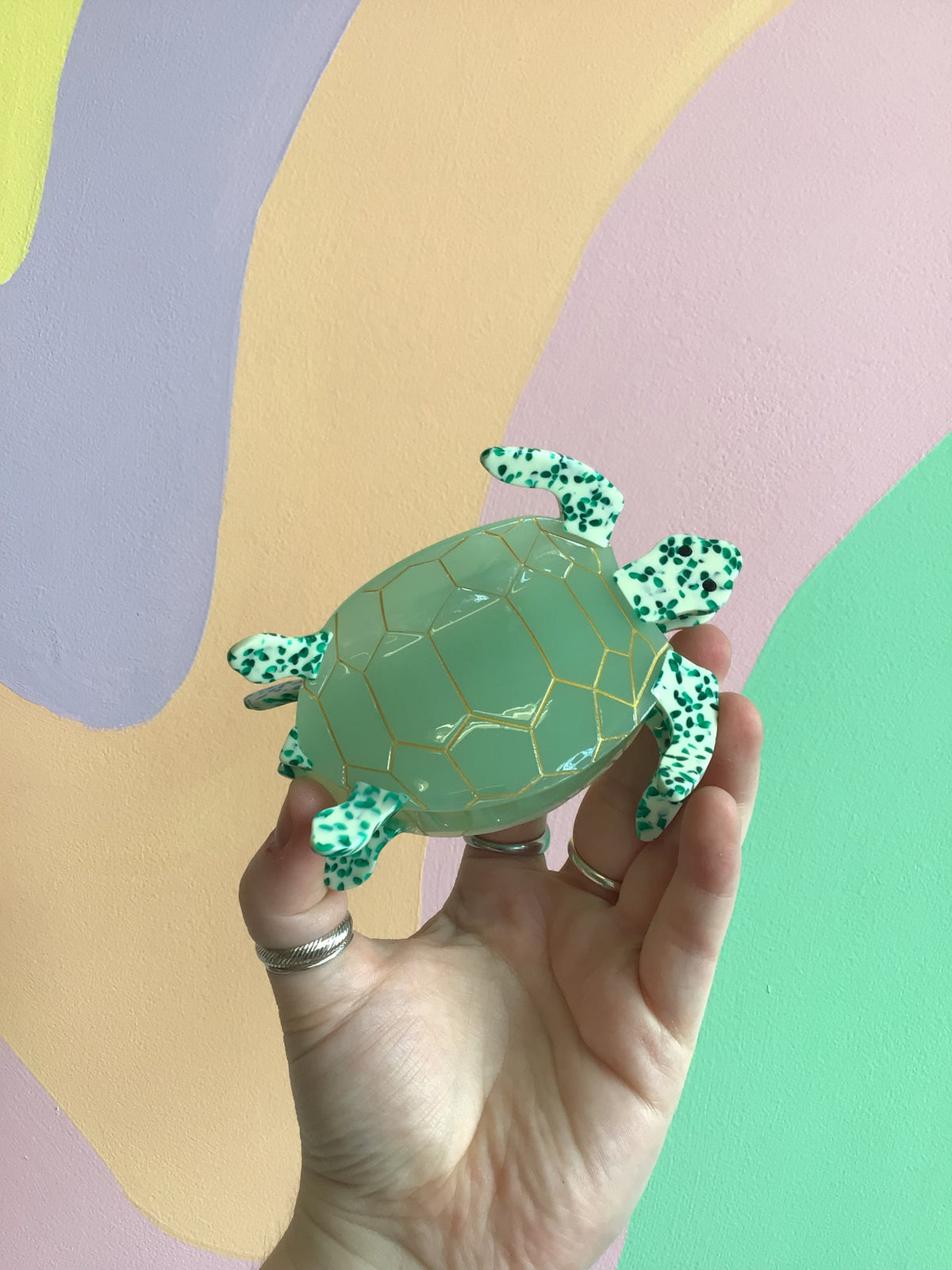 Sea turtle hair claw with light green shell and speckled teal flippers