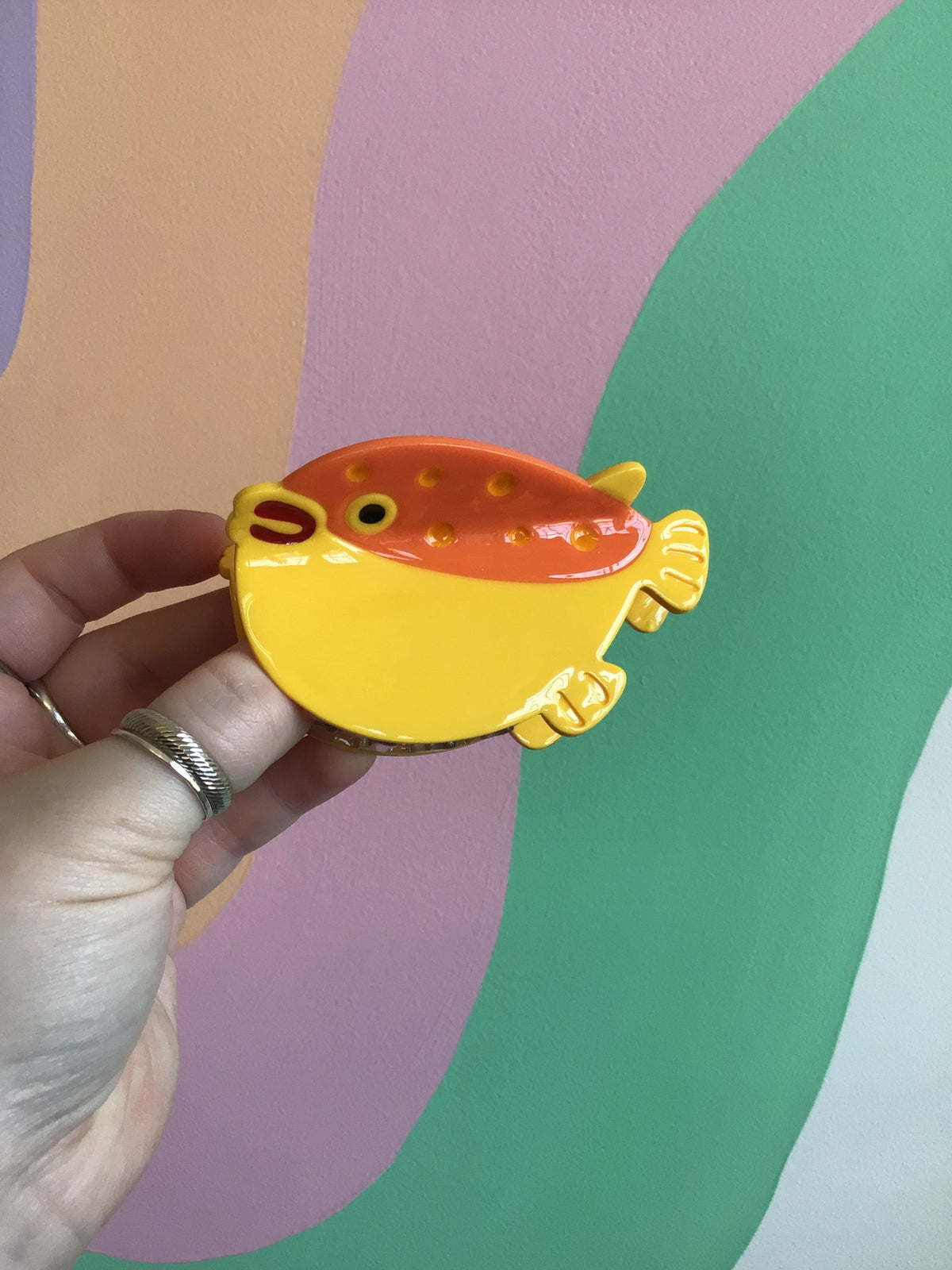 Yellow and orange fish-shaped hair claw with small star and dot decorations