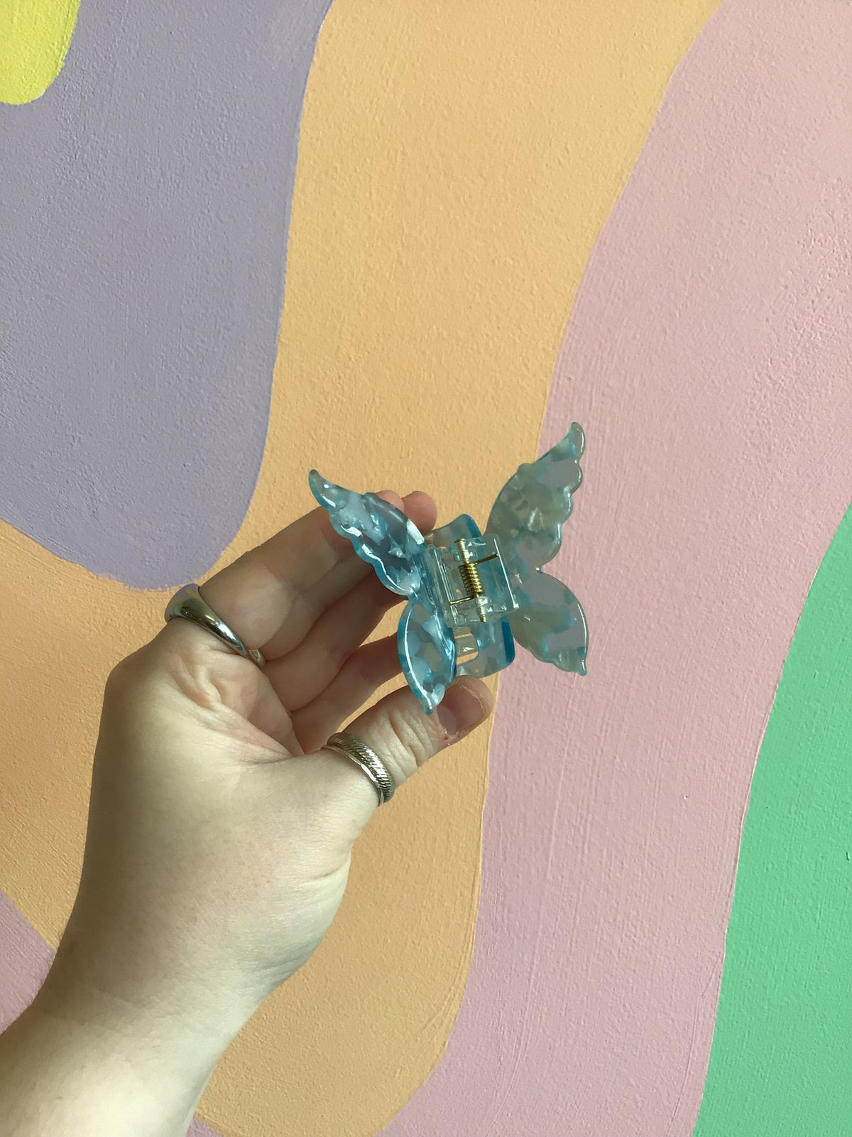 Butterfly hair claw with teal-blue translucent wings and gold-tone center hinge