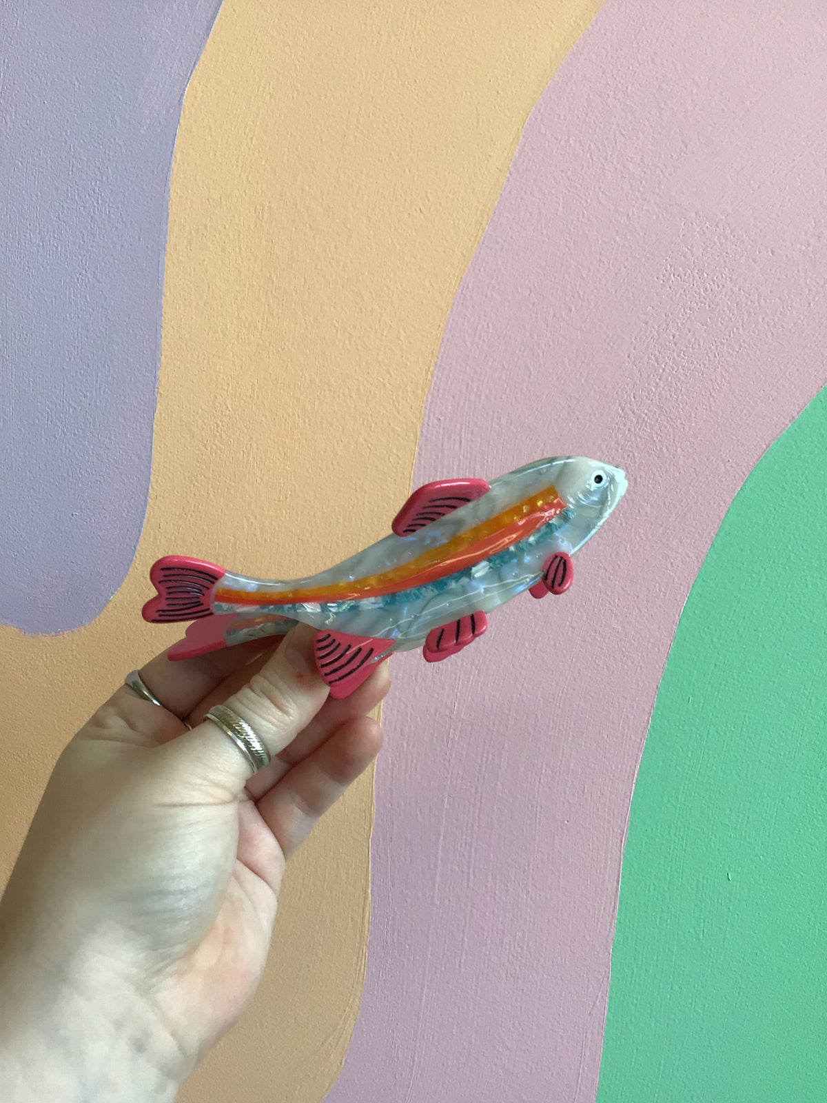 Fish-shaped hair claw clip with teal, red striped body and clear tail