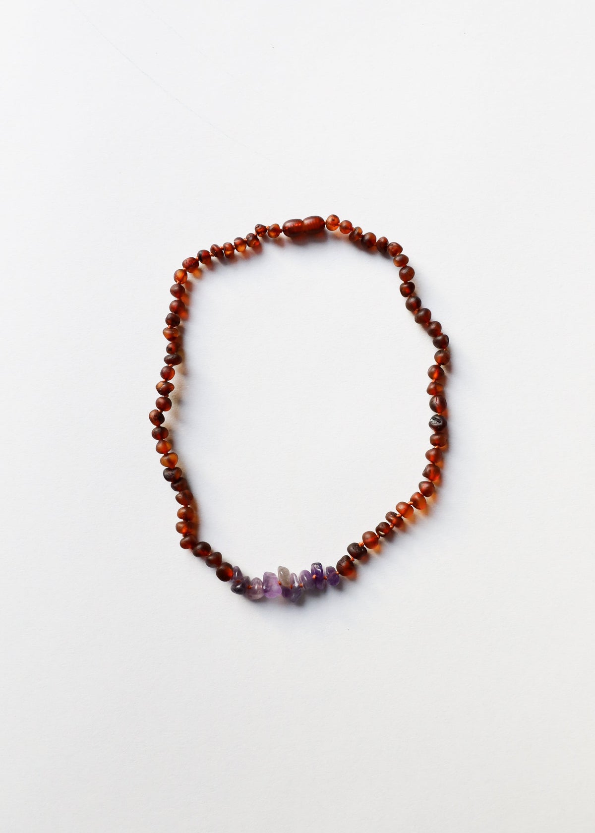Amber bead necklace with three purple amethyst accents along the bottom edge.