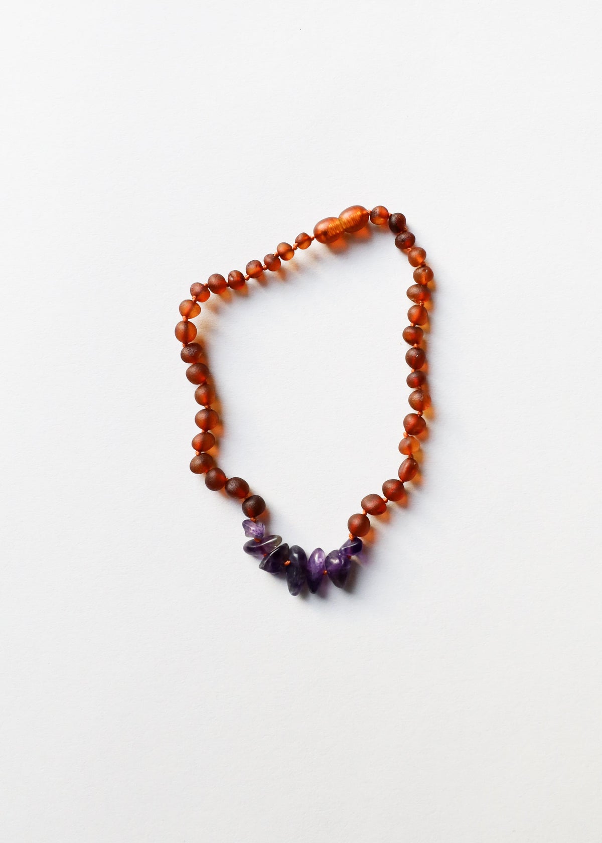 Raw amber bead necklace with purple amethyst accents at the center bottom