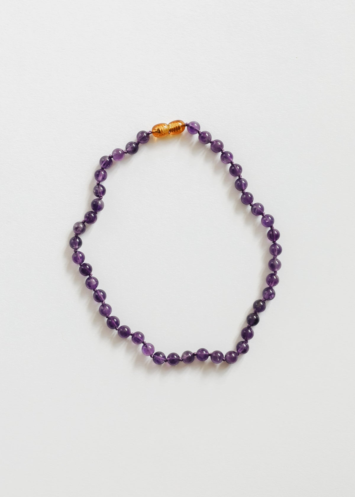Amethyst bead necklace with purple faceted stones and small amber spacer beads