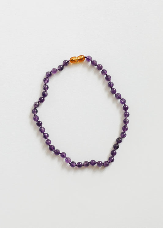Amethyst bead necklace with purple faceted stones and small amber spacer beads
