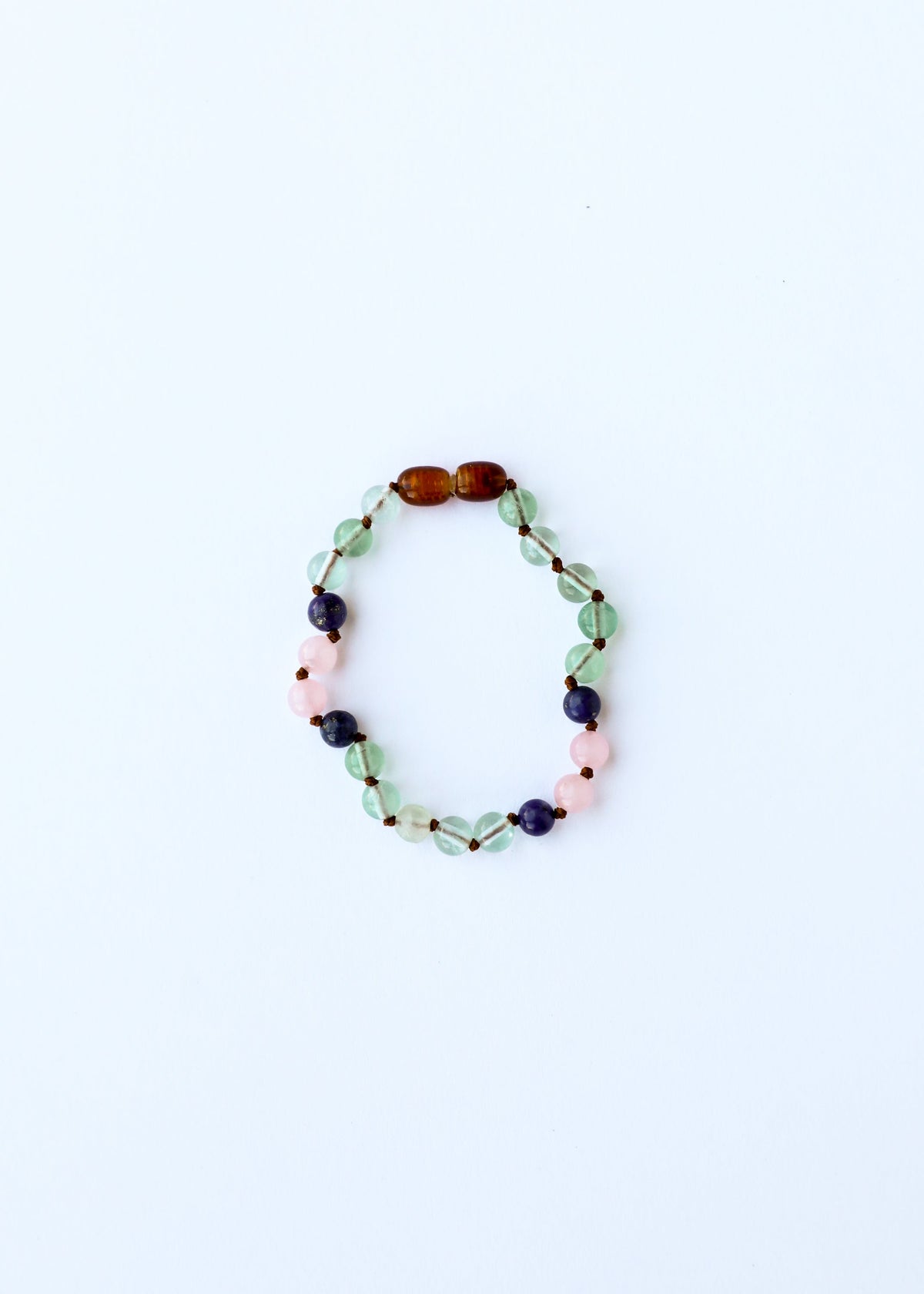 Beaded gemstone bracelet with green, pink, and blue beads on a round oval strand