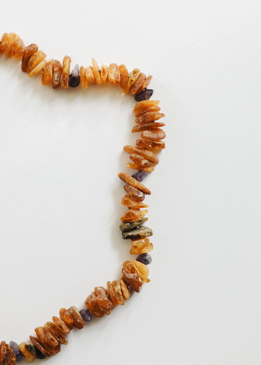 Raw amber and amethyst pet necklace closeup, orange chips with dark purple rough beads