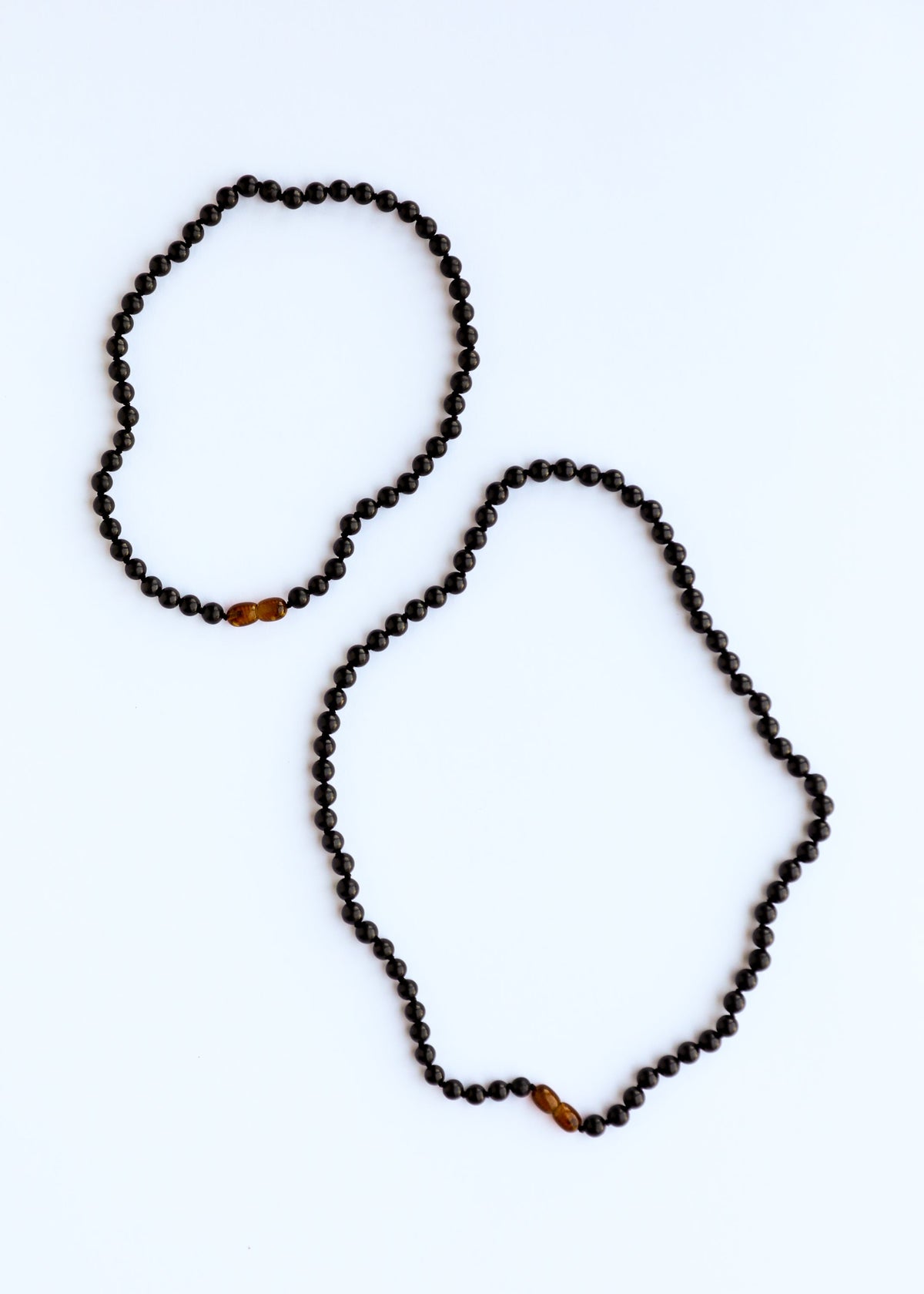 Two black shungite beaded bands: one with amber center bead, one without