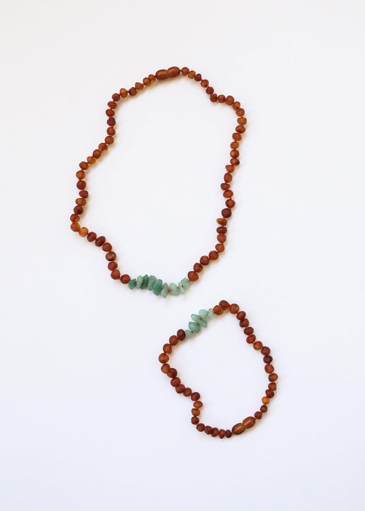 Raw amber bead necklace with green aventurine chip accents, shown with a second strand