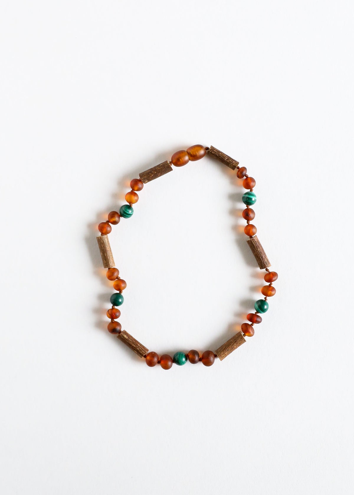 Amber and malachite beaded necklace with oval amber center bead and teal accents