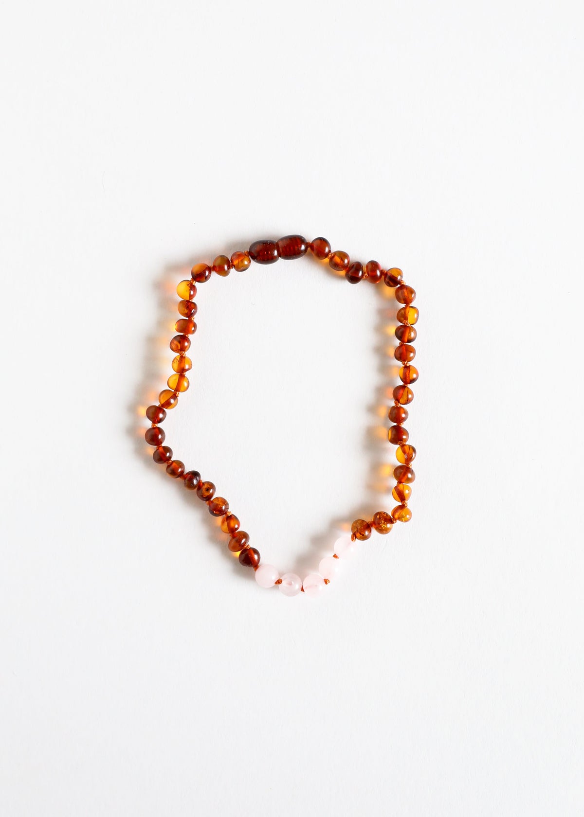 Amber-brown bead necklace with pale rose quartz drop accents