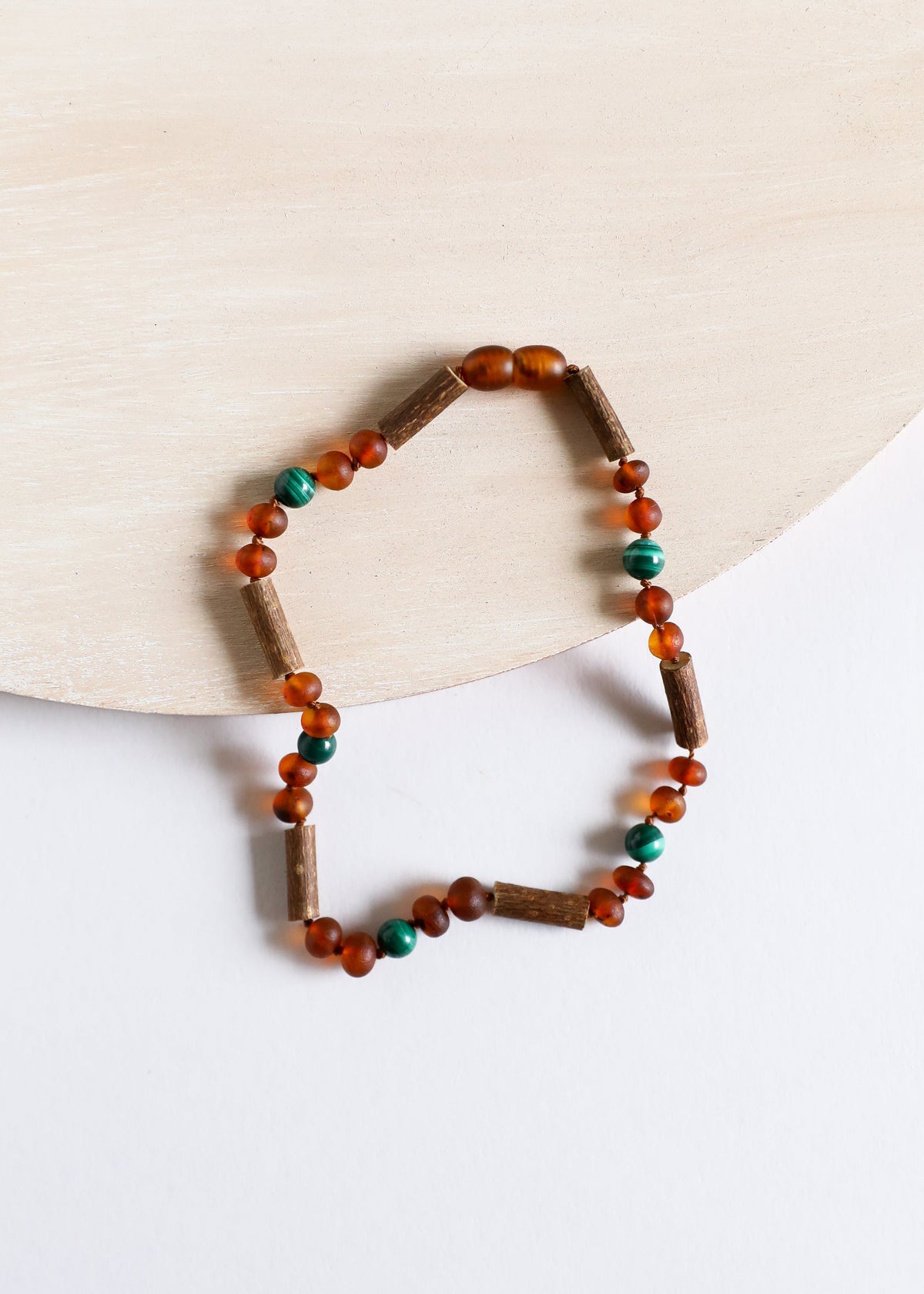 Amber and malachite beaded necklace with dark brown tube beads and teal accents