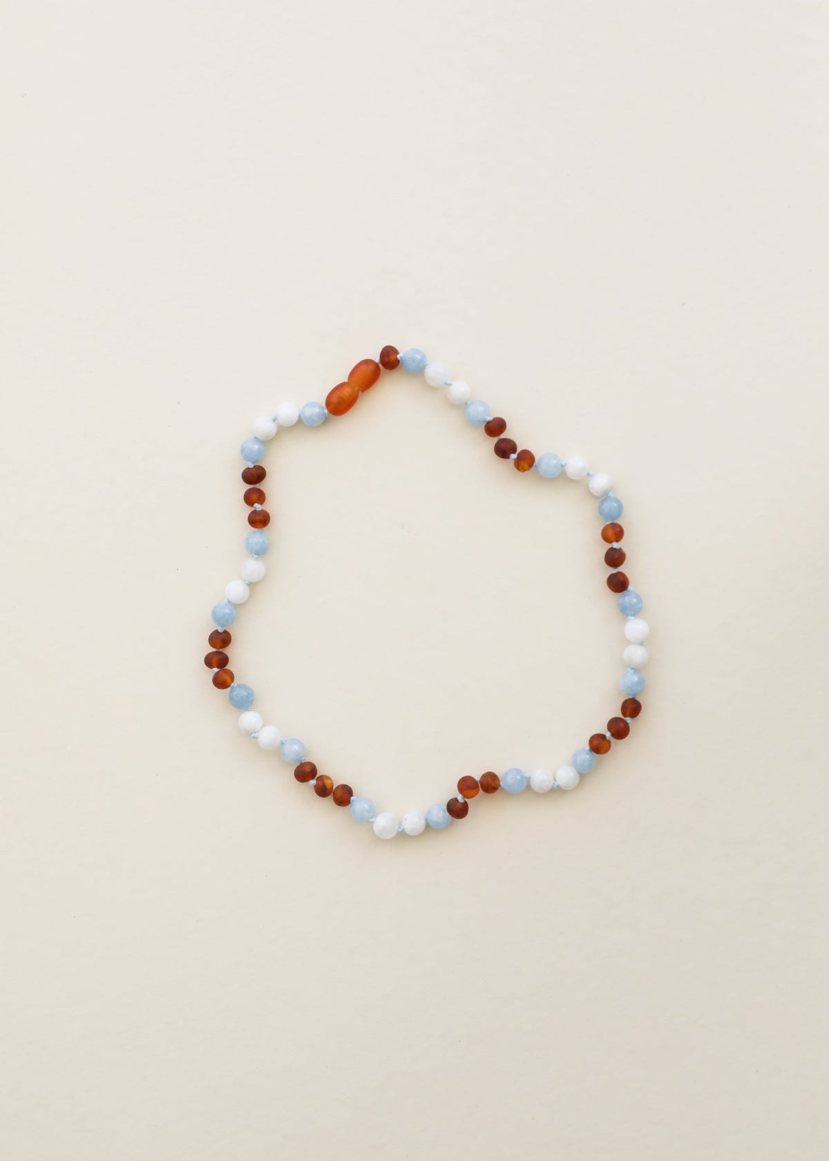 Beaded gemstone necklace with white, light blue and dark amber-brown beads