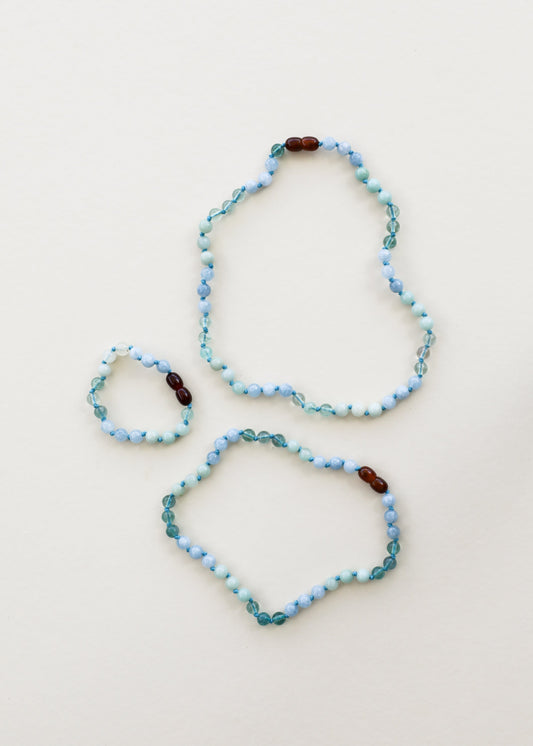 Two light blue gemstone beaded bracelets with dark brown accent beads
