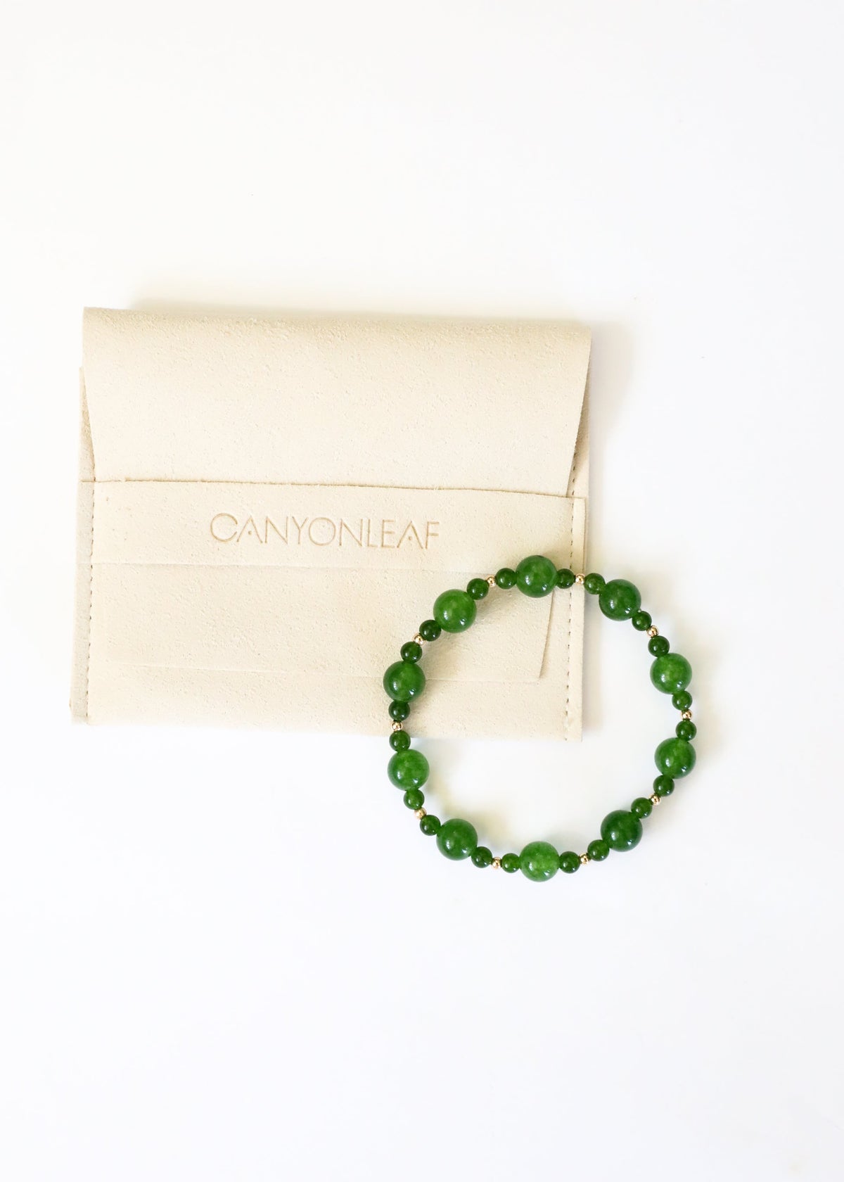 Green jade beaded stretch bracelet on white jewelry box