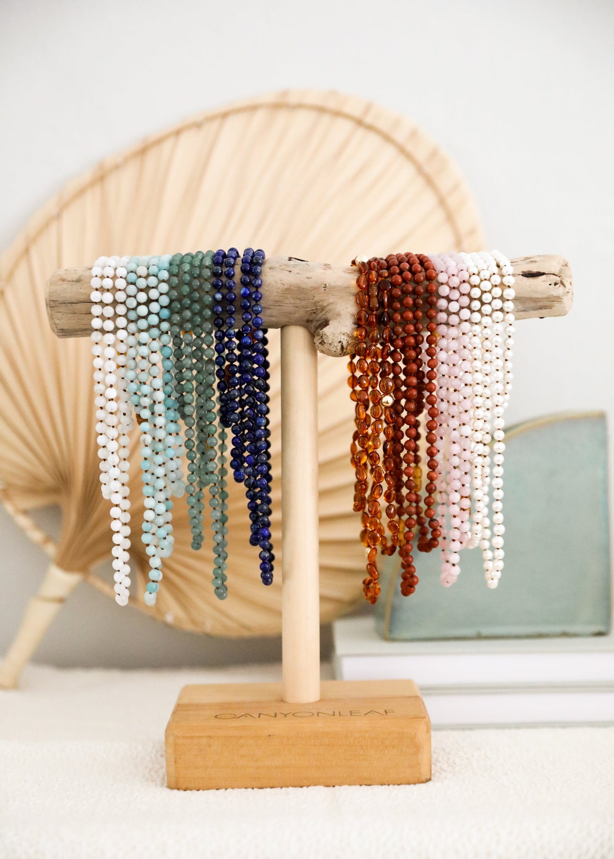 Beaded gemstone and pearl bracelet set on display stand: turquoise, blue, orange, white