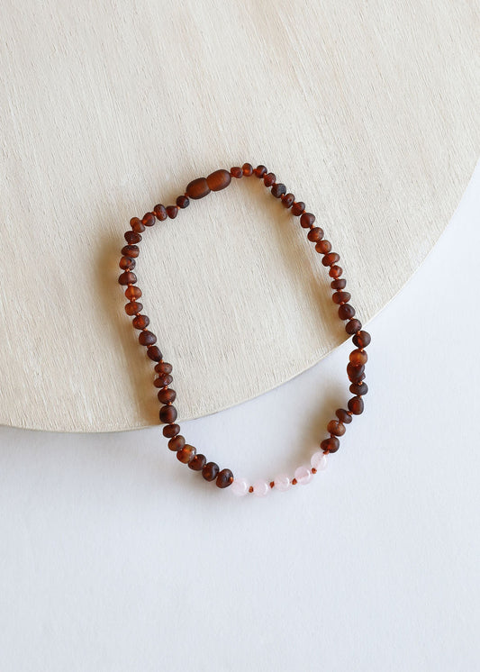 Amber bead necklace with small pink accents, looped