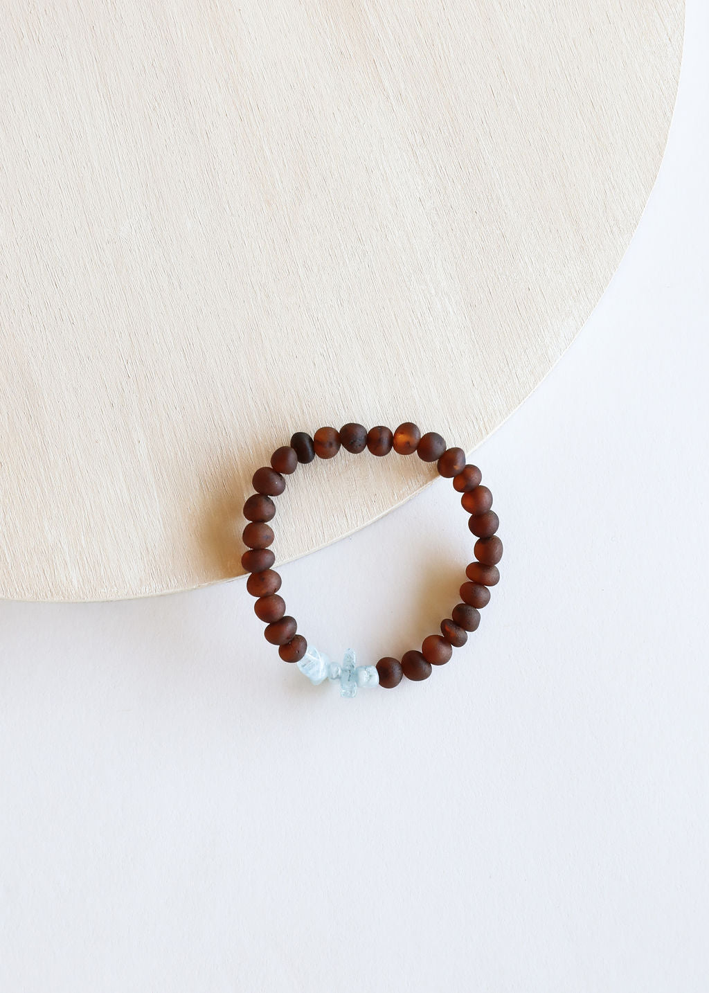 Adult beaded bracelet with dark brown beads and raw light blue stone accent