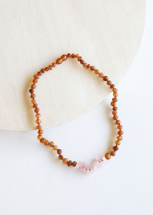 Raw cognac amber beaded necklace with small pink stone cluster at bottom