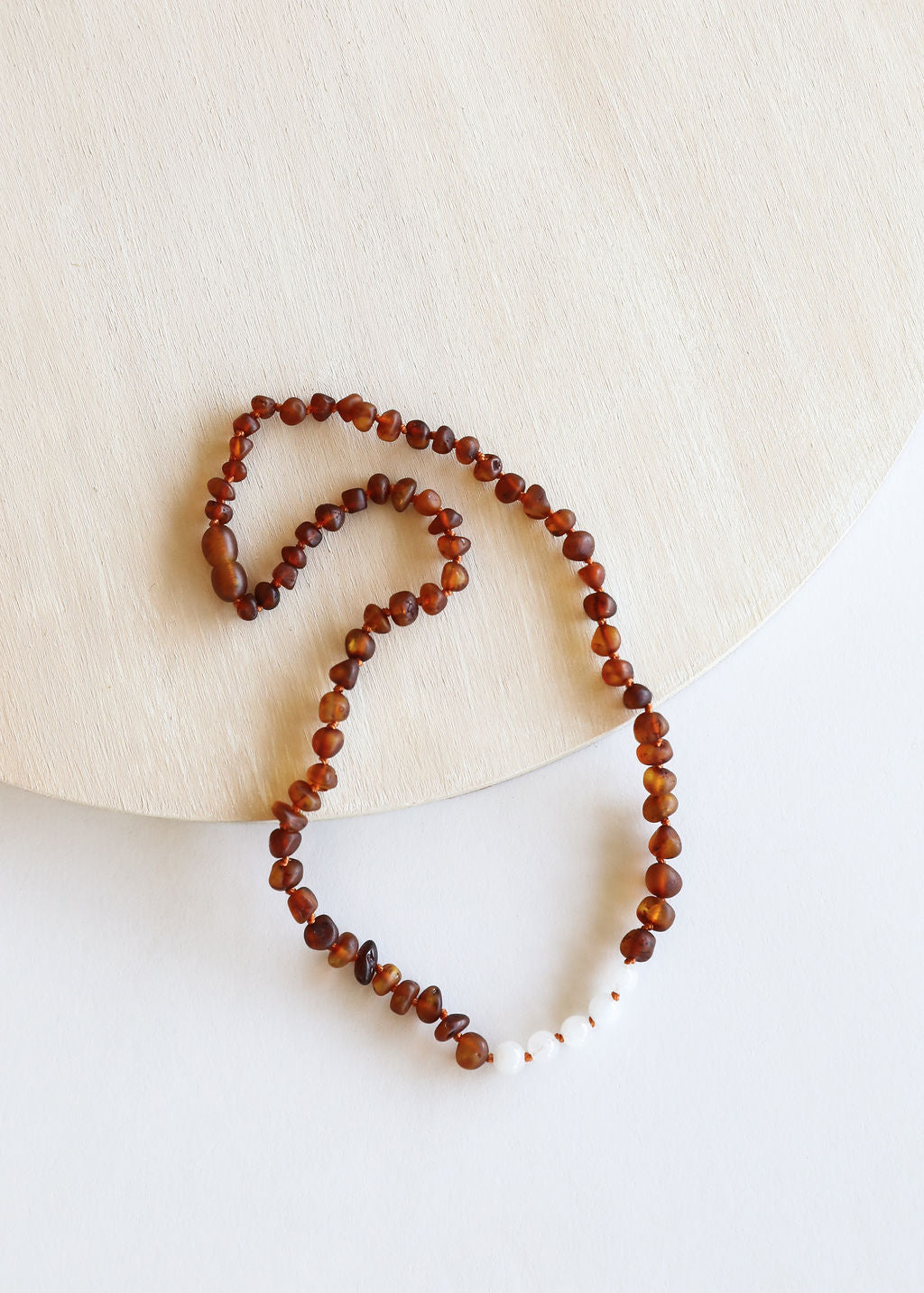Brown bead necklace with white moonstone accents in a heart-shaped loop