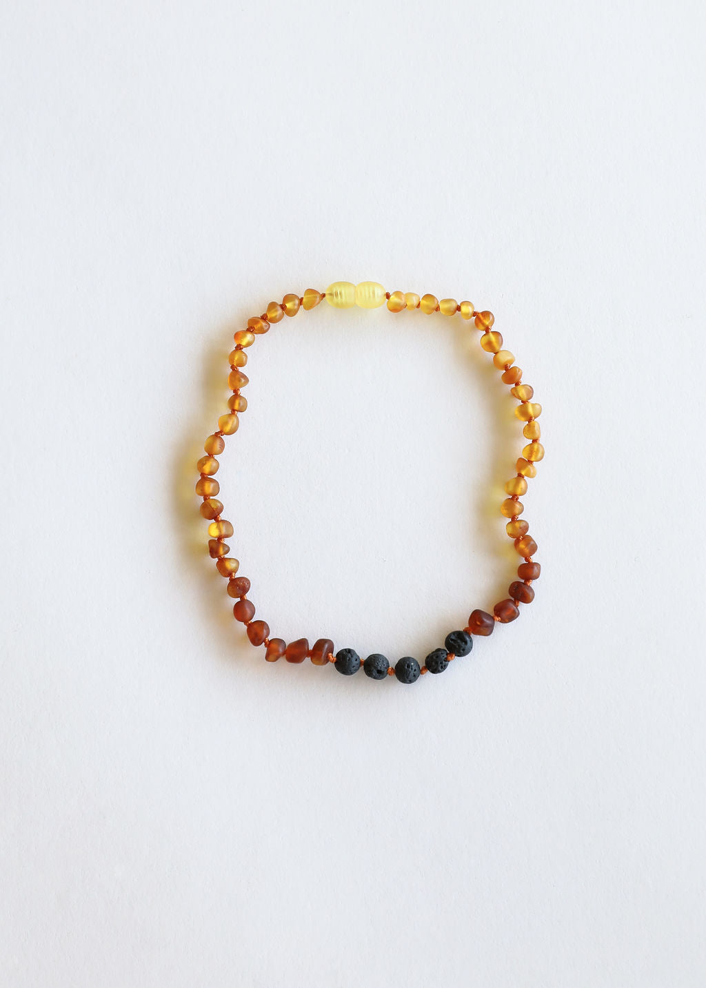 Beaded ombre amber necklace with small black lava beads at the bottom edge