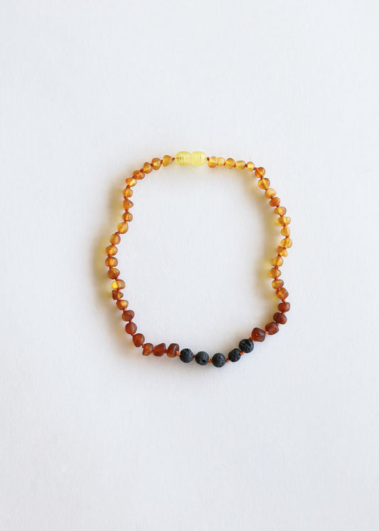 Beaded ombre amber necklace with small black lava beads at the bottom edge