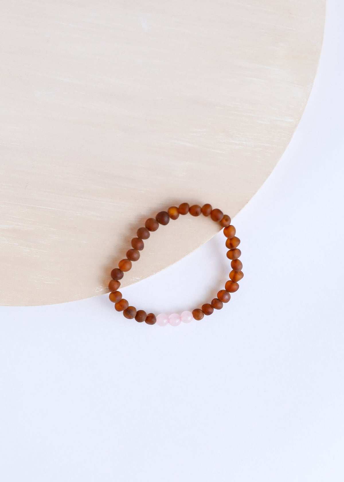 Brown amber bead bracelet with small white beads on elastic band