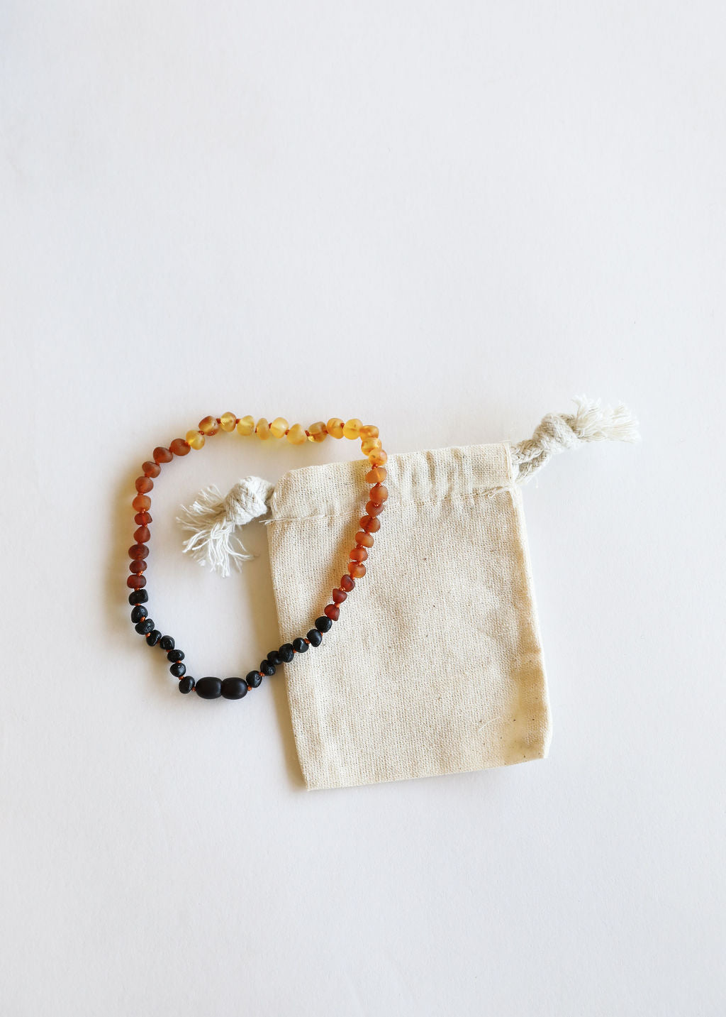 Ombre Baltic amber bead necklace on drawstring pouch, dark to honey gradient