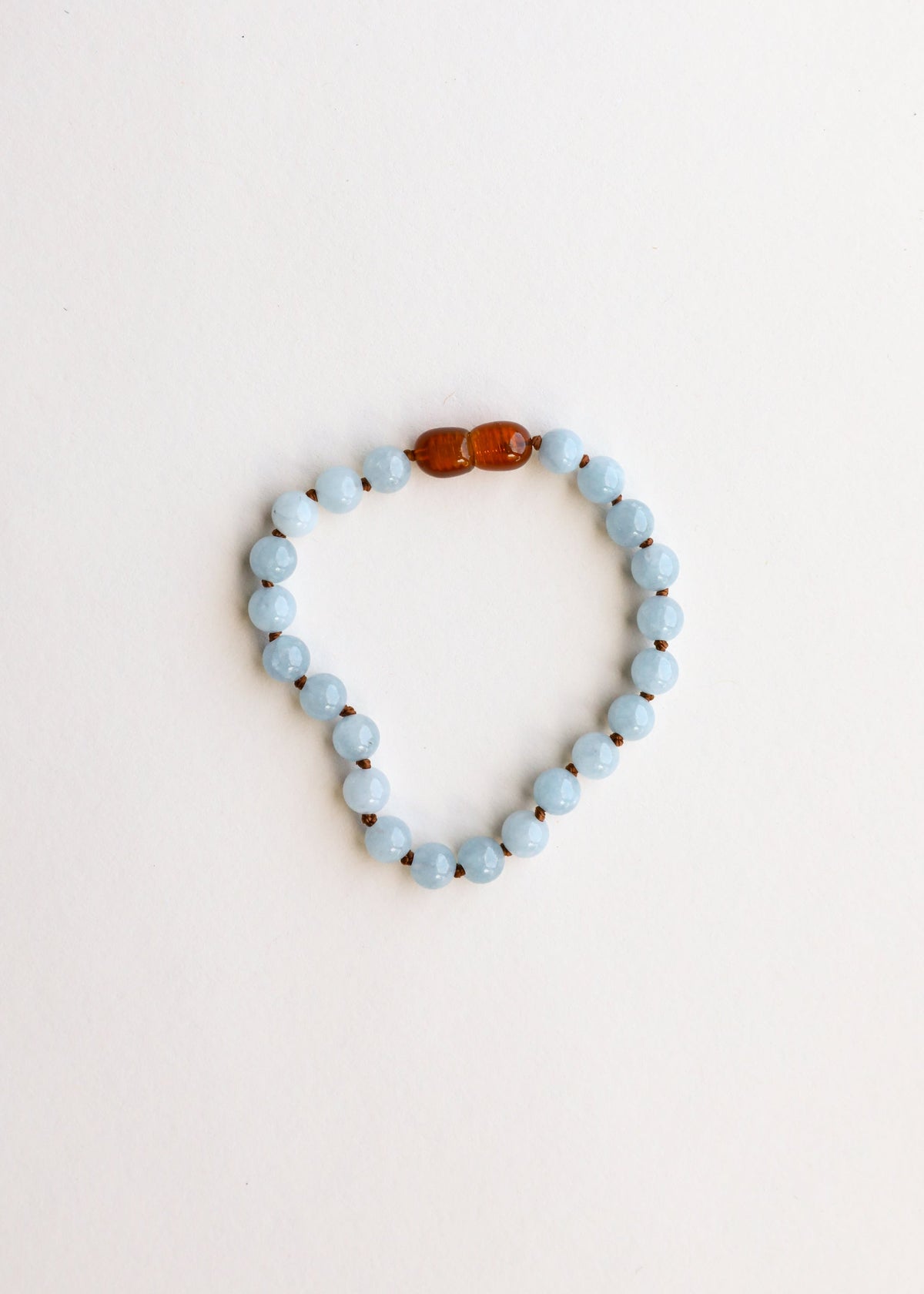 Aquamarine bead bracelet loop with amber bead spacer across the top
