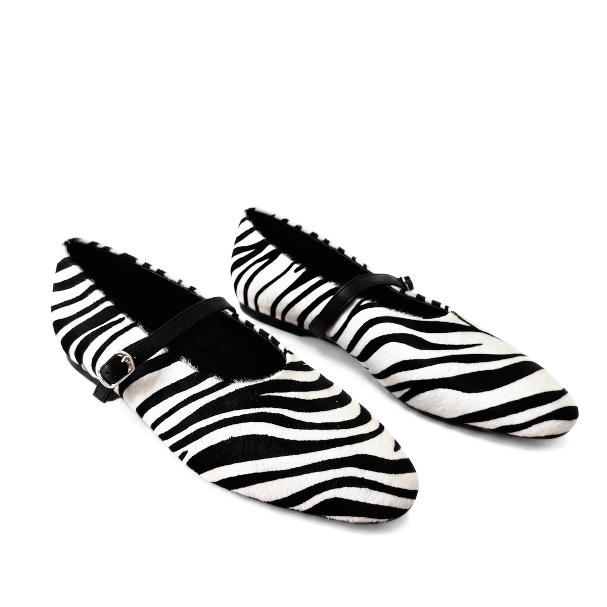 Pair of zebra-print flats with black buckle straps and fringe trim