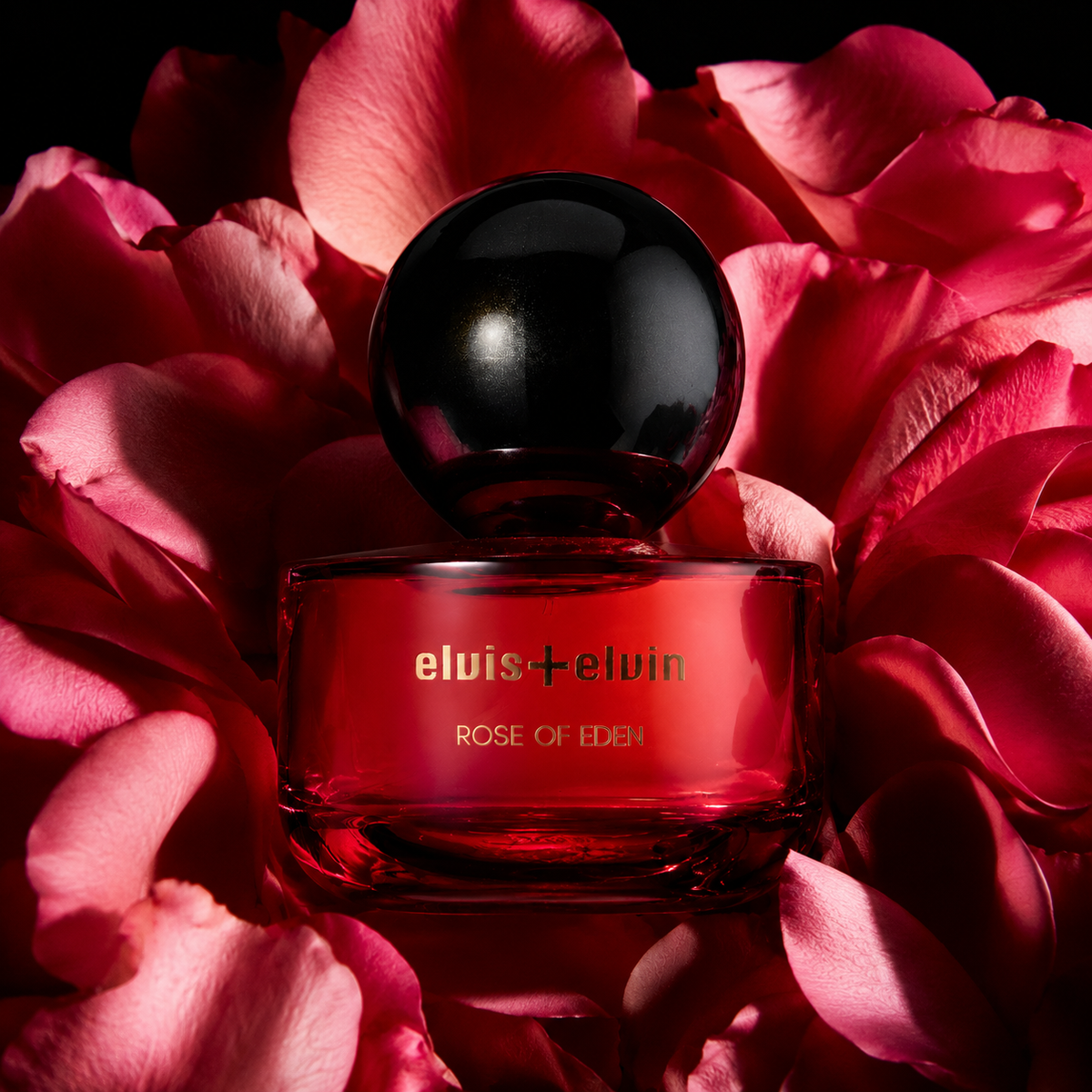 Rose of Eden perfume bottle with red liquid and black cap on rose petals