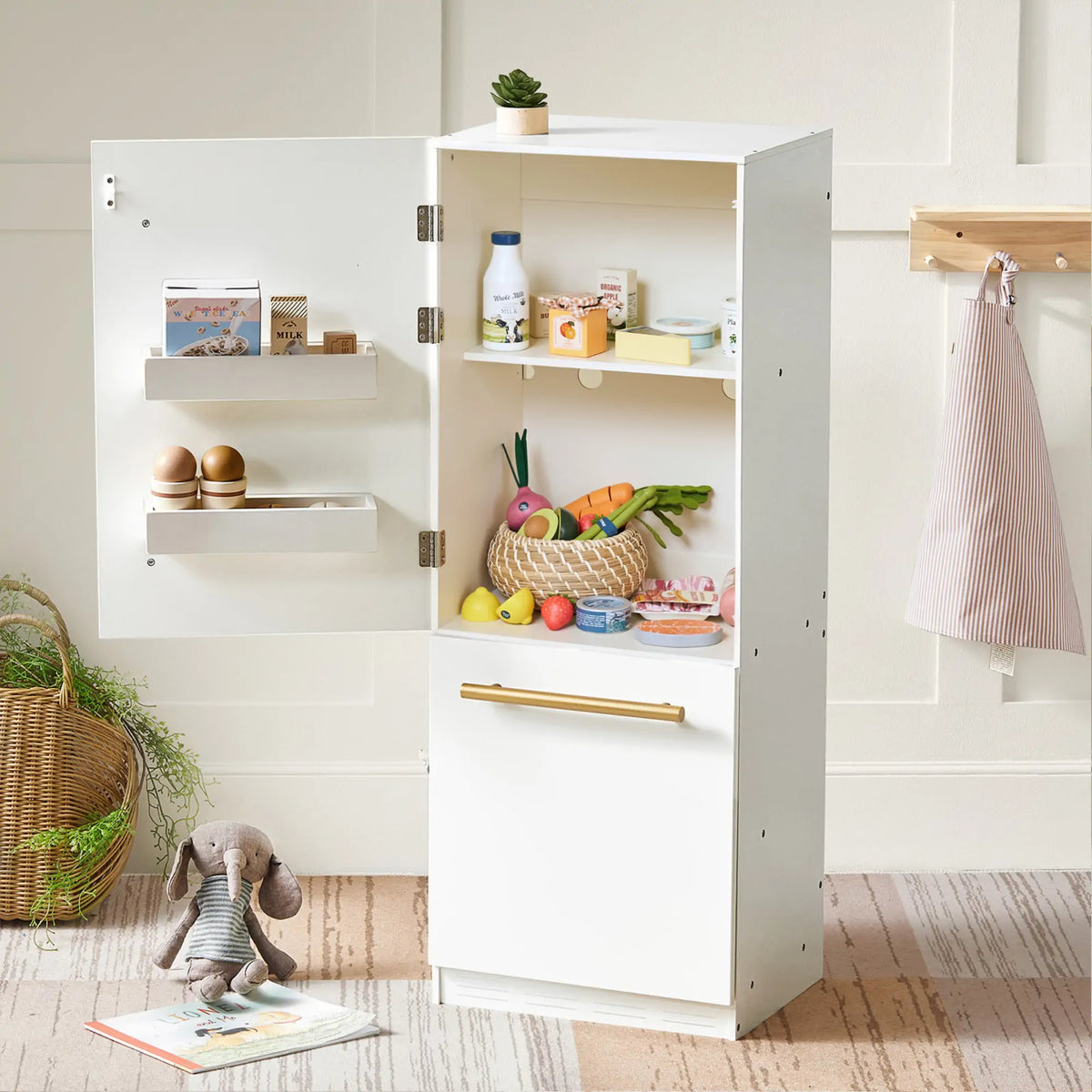 White play kitchen cabinet stocked with dairy play food and accessories