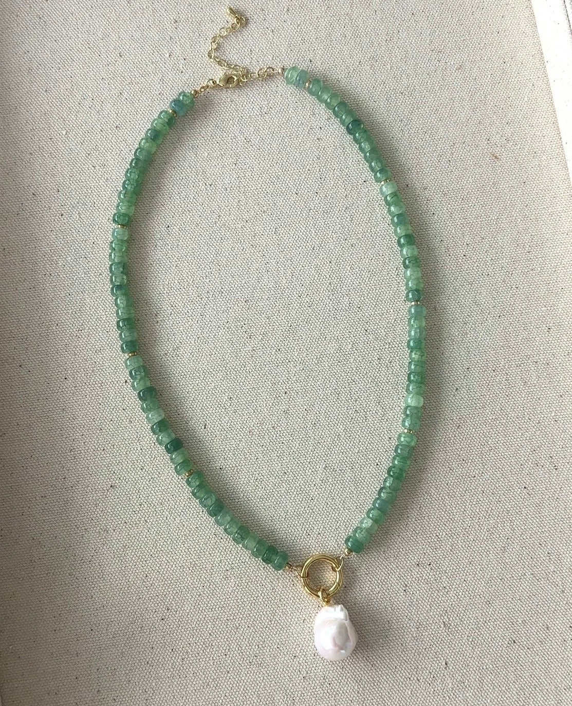 Green beaded necklace with gold ring clasp and small pink pearl drop