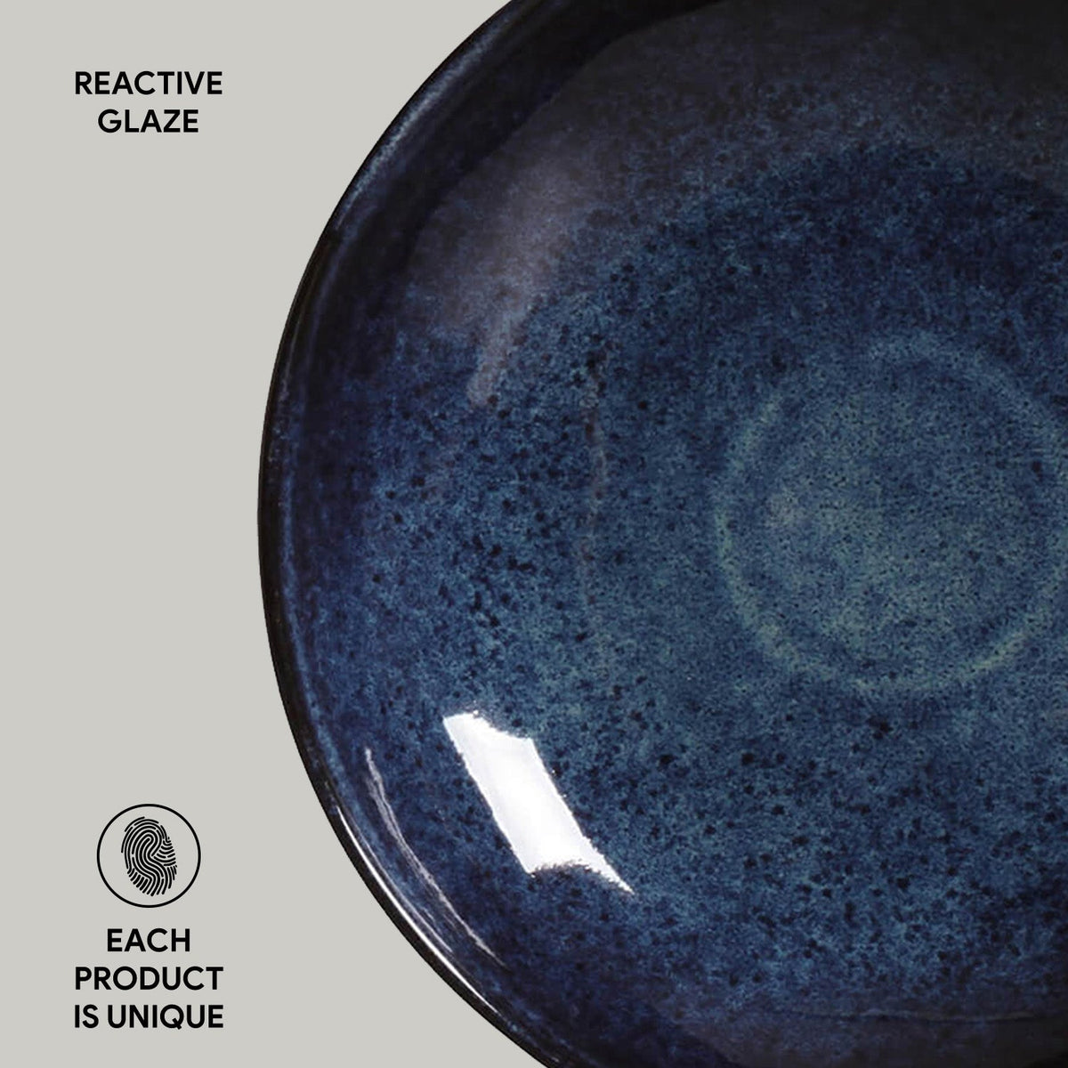 Navy reactive glazed pasta plate close-up, speckled surface with glossy highlight