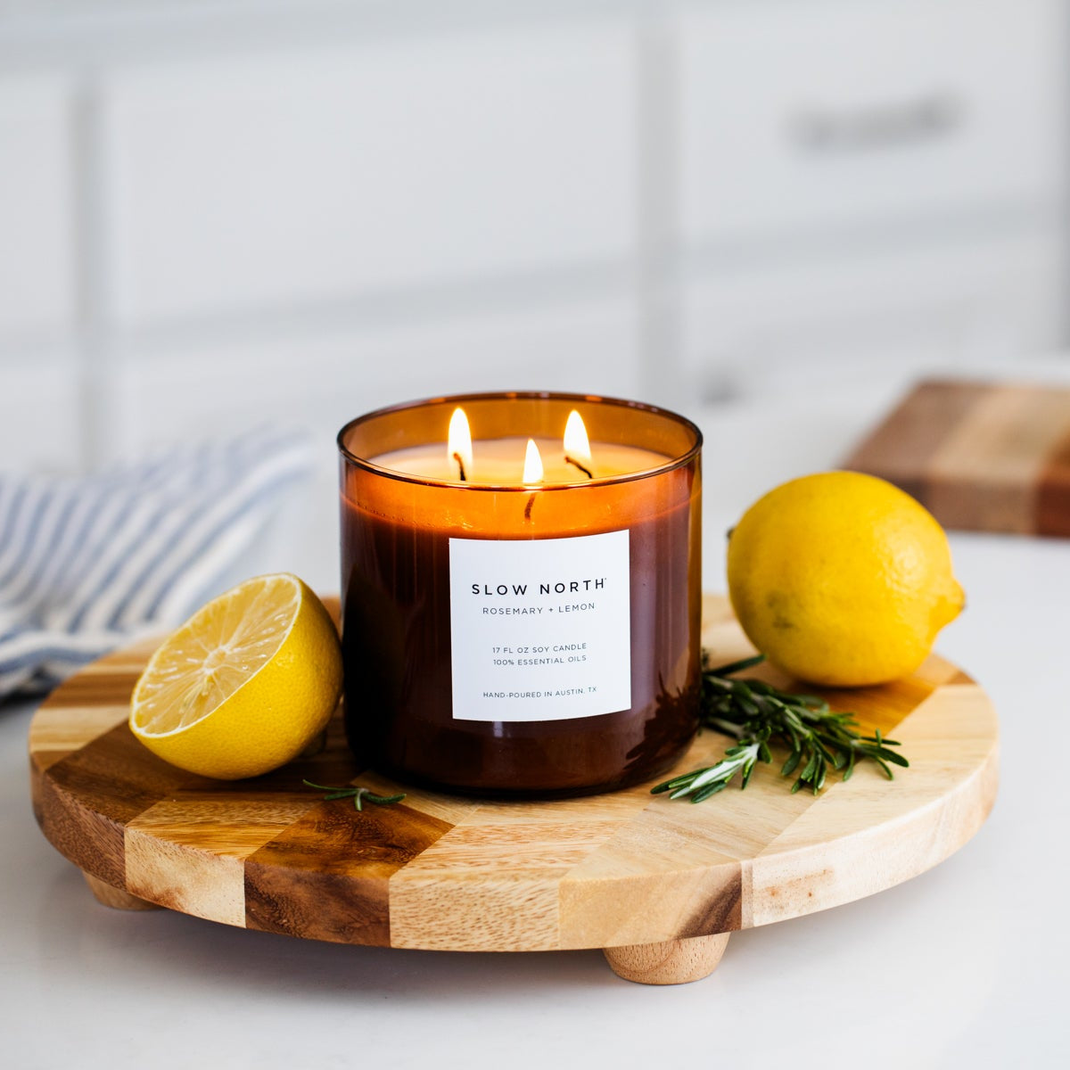 Brown 3-wick soy candle with three lit flames and front label