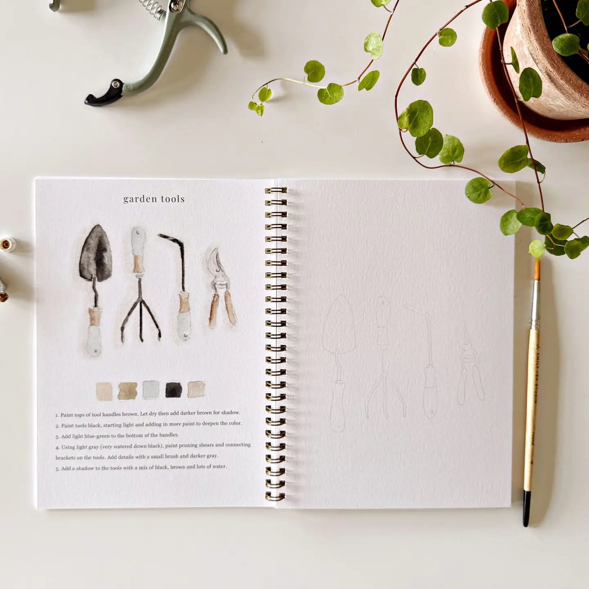 Open Garden watercolor workbook with watercolor garden tools study and blank right page
