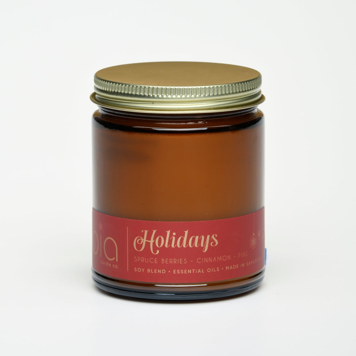 Amber soy candle jar with metal lid and “Holidays” label on front