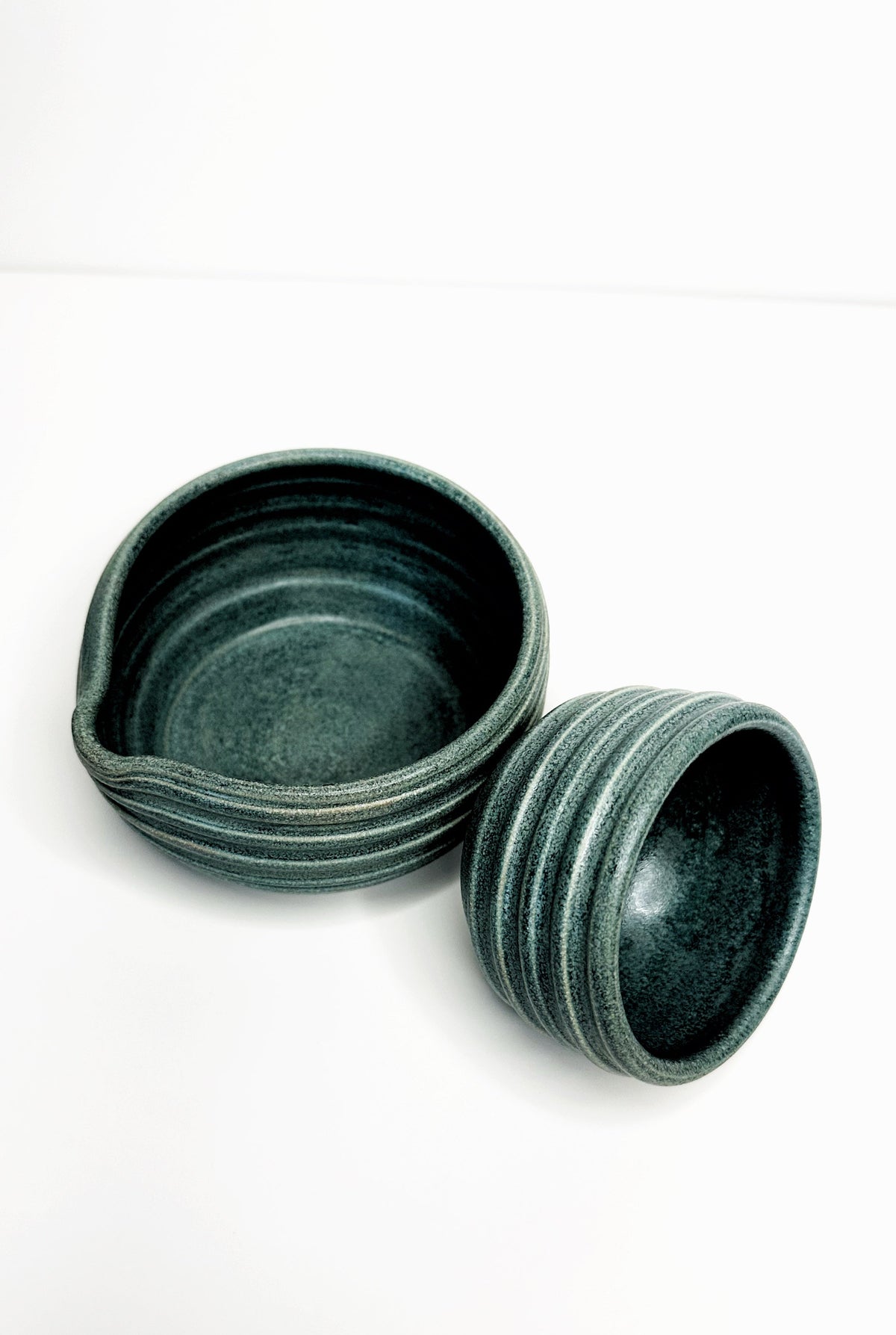 Forest green matcha bowl stack with matching mini cup, ceramic with textured glaze.