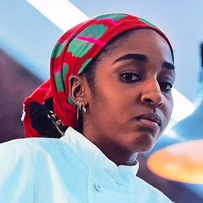 Red patterned bandana headscarf with green chard leaves, tied back