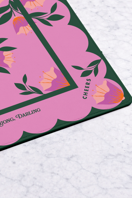 Mahjong mat corner with pink floral print and dark green border, scalloped edge trim