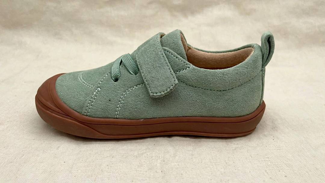Single kids’ light green barefoot sneaker with lace-up top and brown cushioned sole
