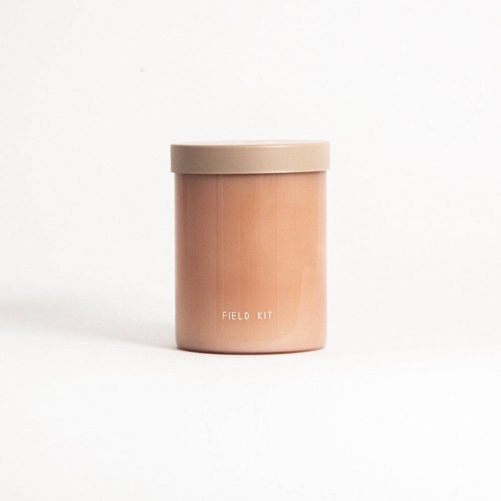 Florist candle in amber jar with light tan lid, 'FIELD KIT' printed on front