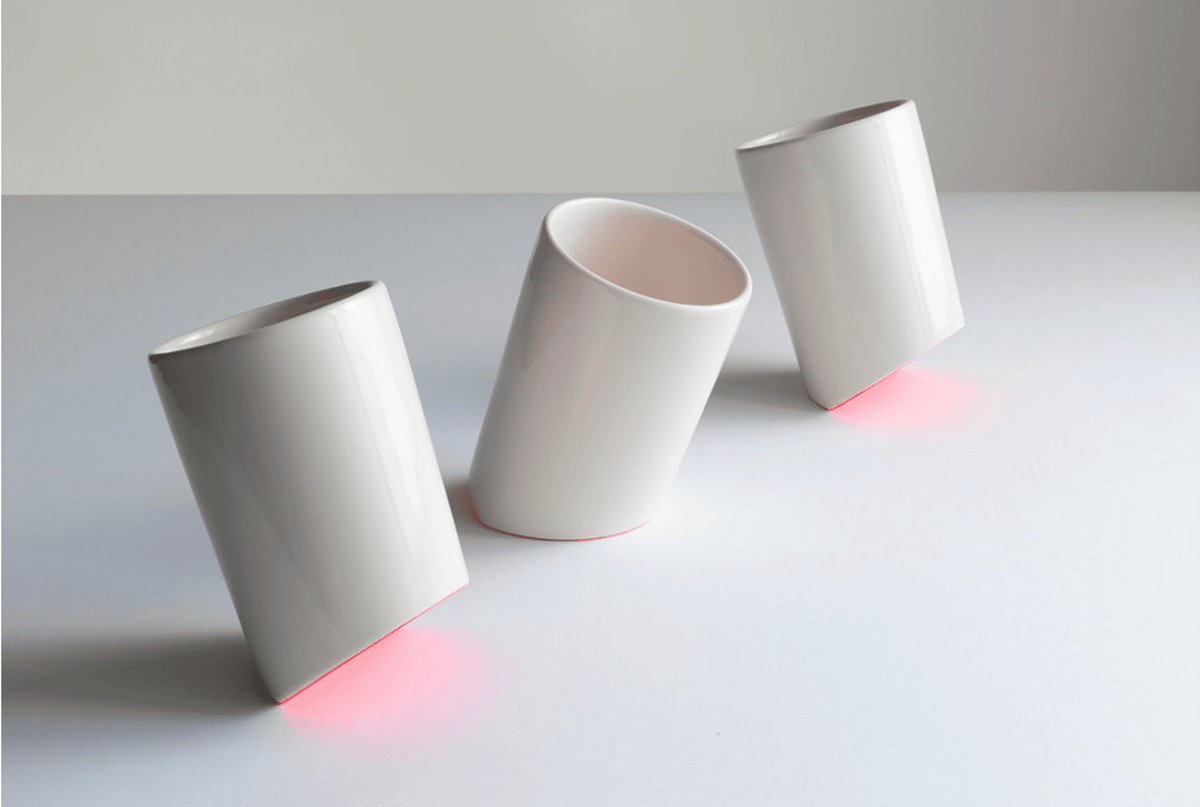 Ceramic cups set of three in matte white, angled with visible open tops