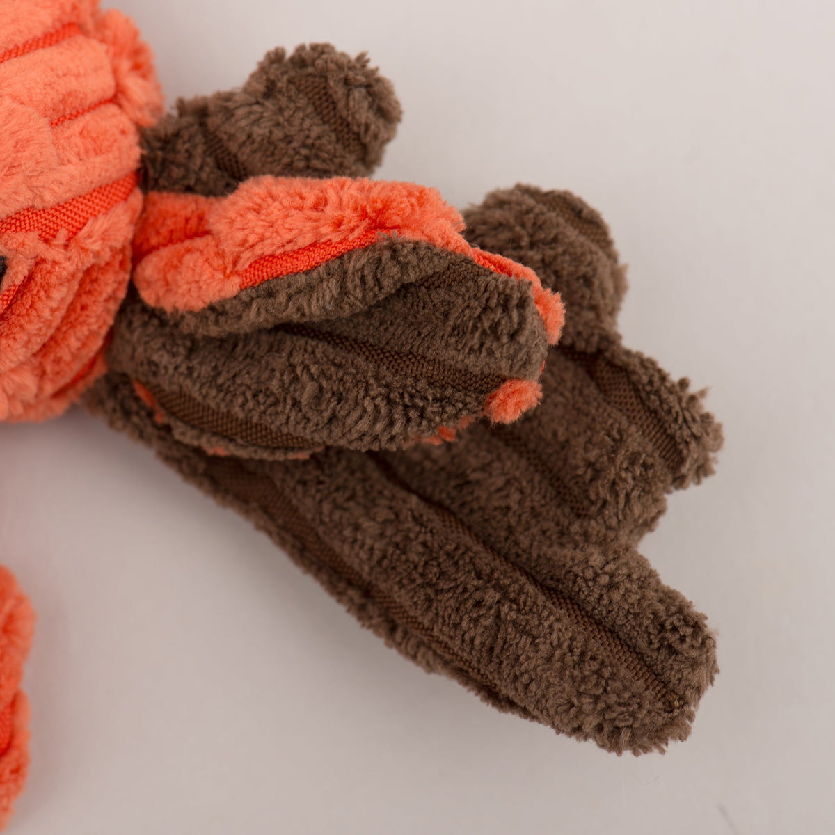 Close-up of brown plush moose antler and orange textured fabric