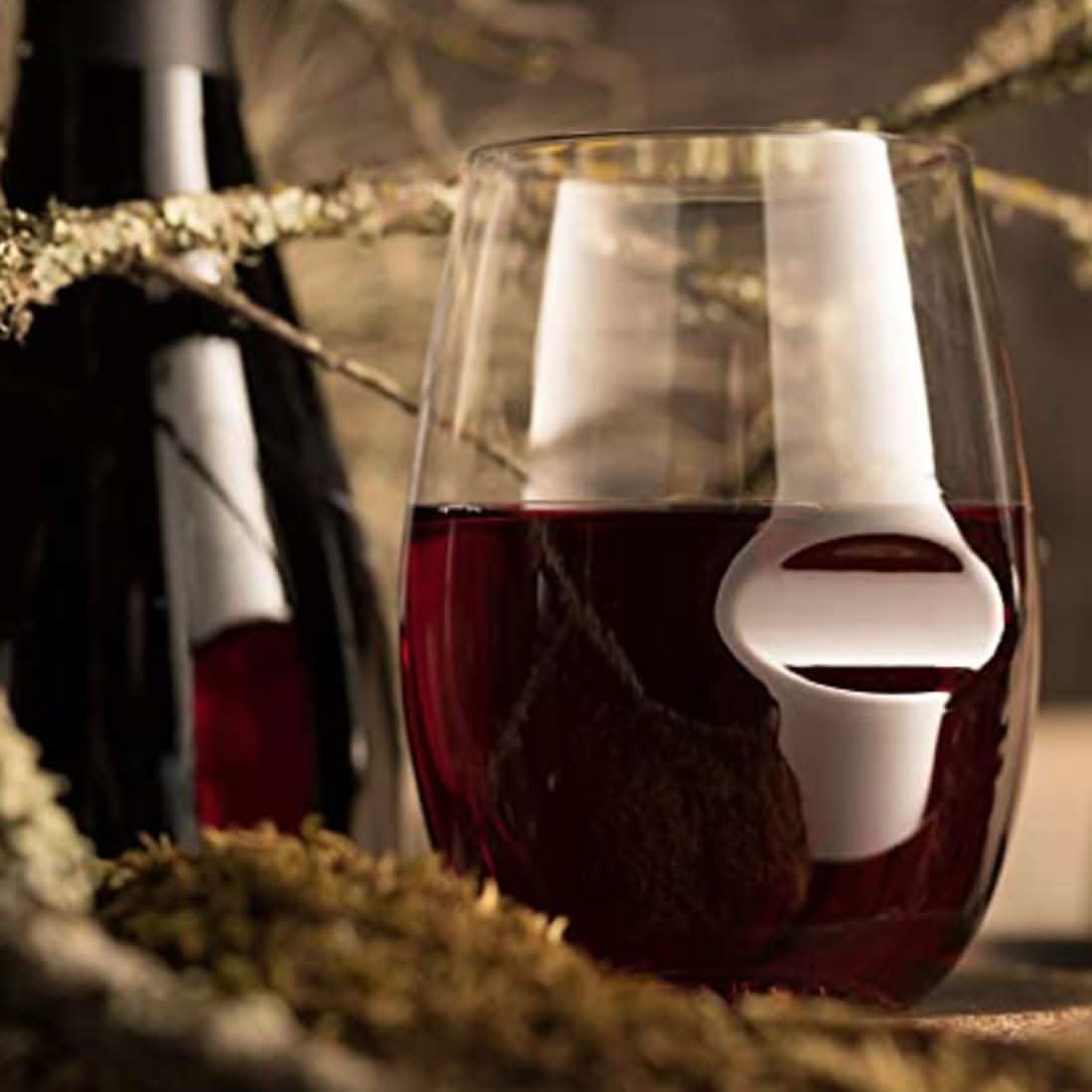 Stemless clear wine glass with red wine, curved rim and wide base