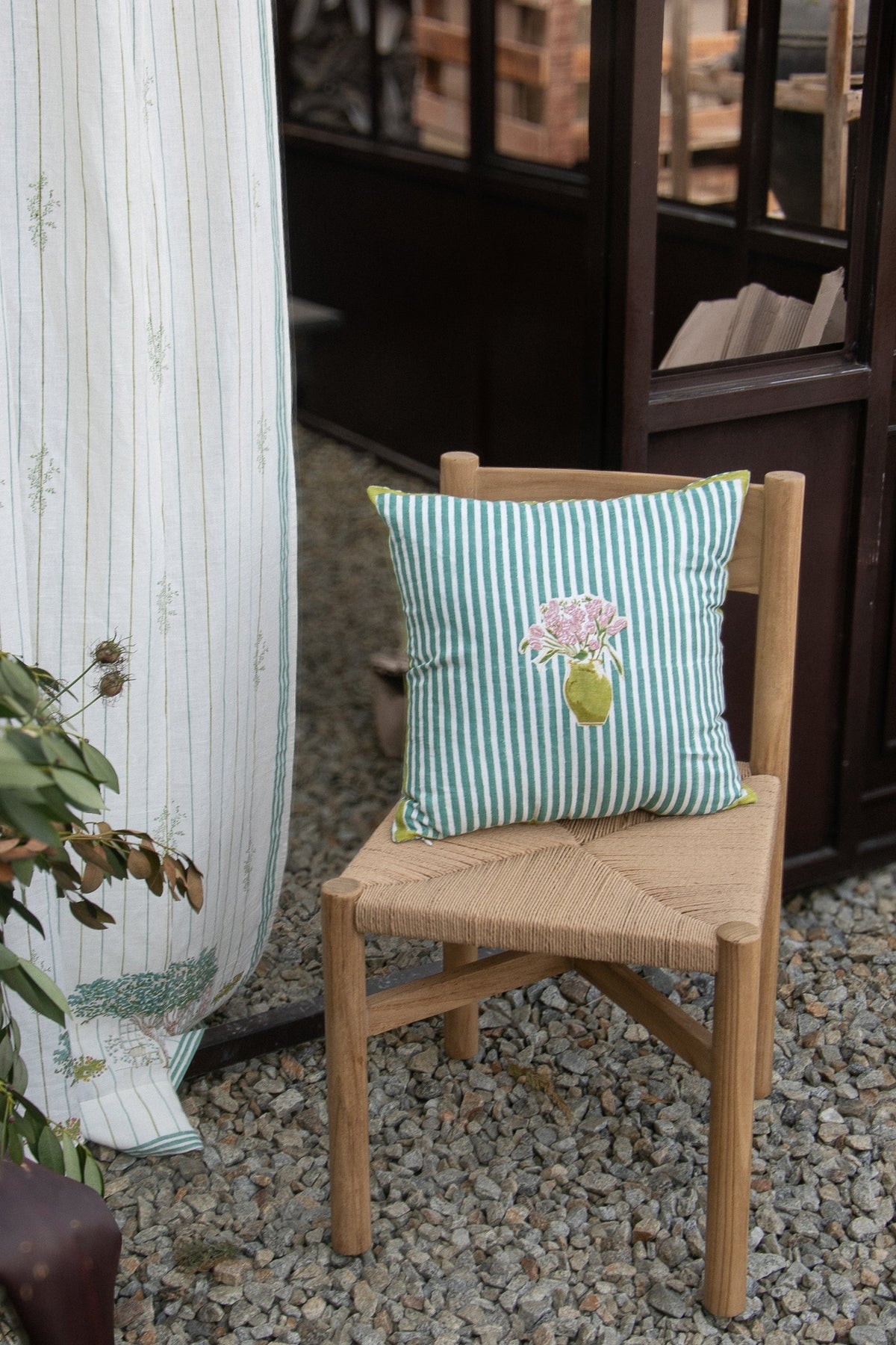 Green striped outdoor chair pillow with floral bouquet applique and yellow edging