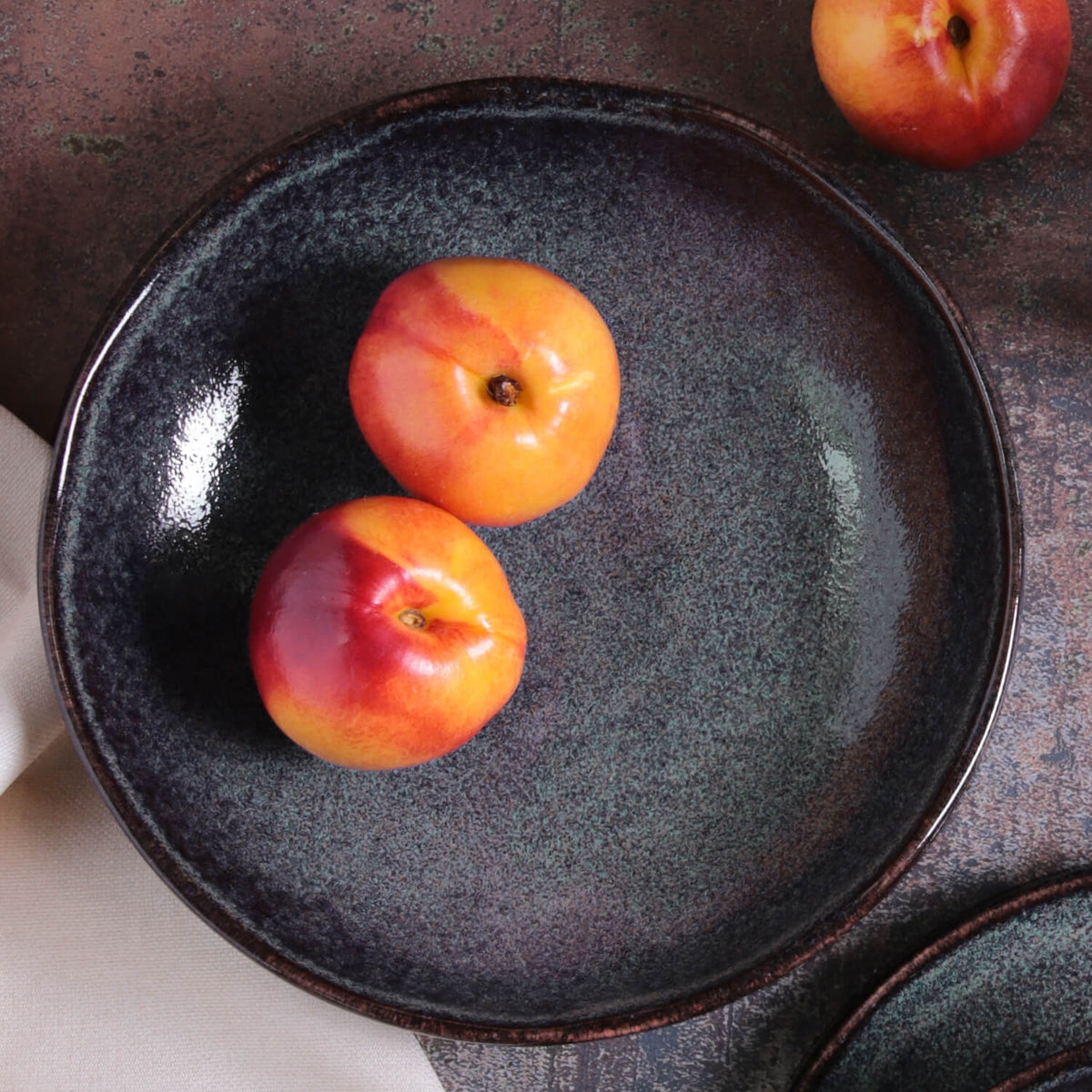 Dark speckled pasta plate, round shallow bowl with raised rim.