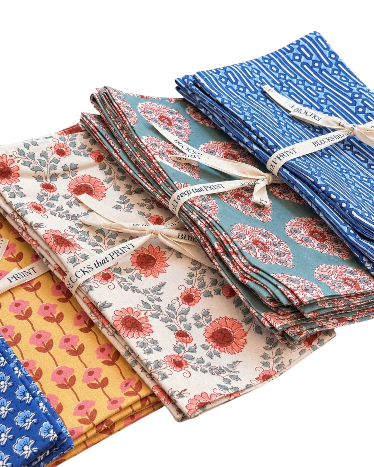 Stack of block-printed napkins in terracotta, blue, and patterned designs