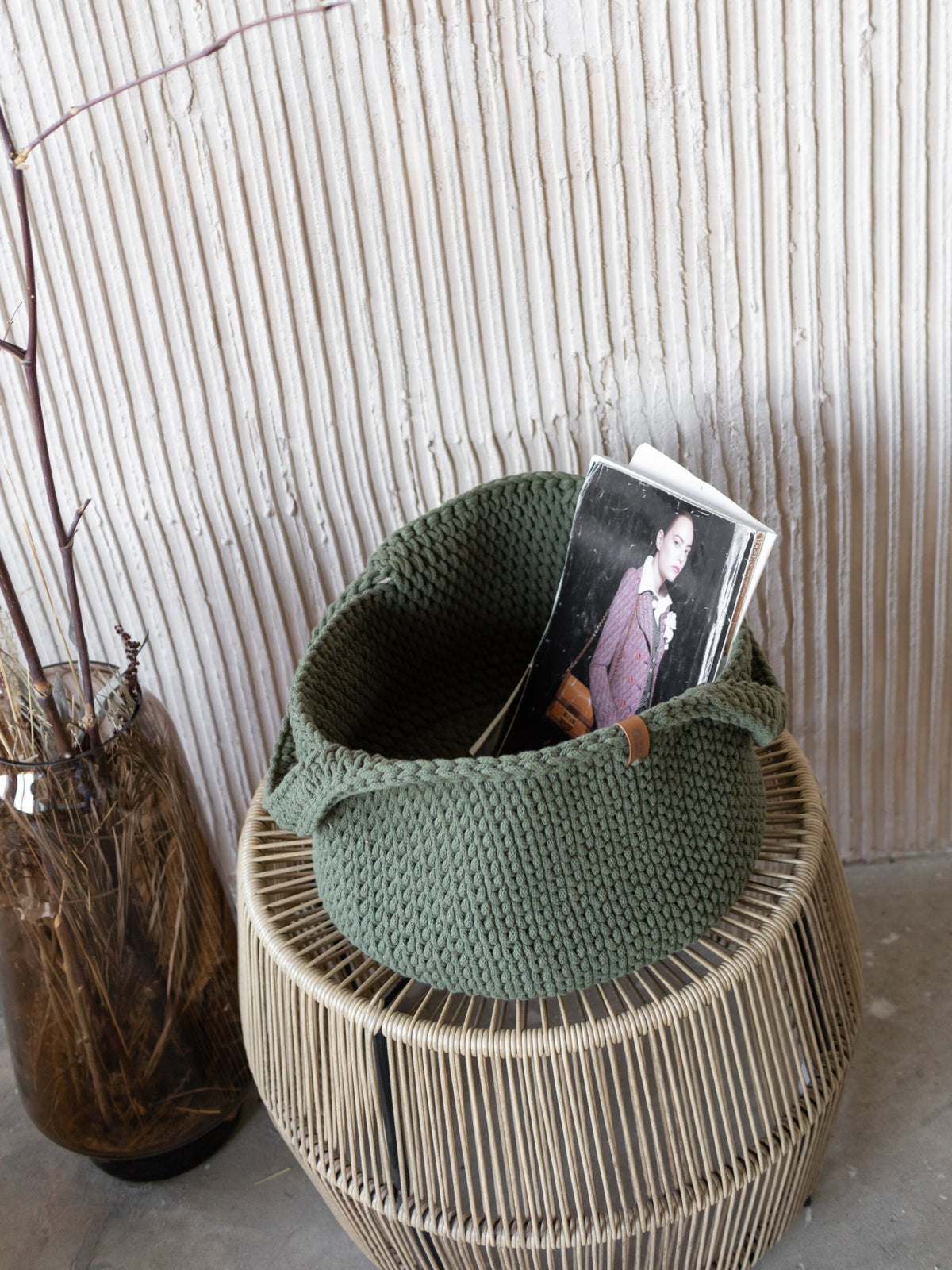 Round woven basket with handles, olive-green with photo card partially inside.