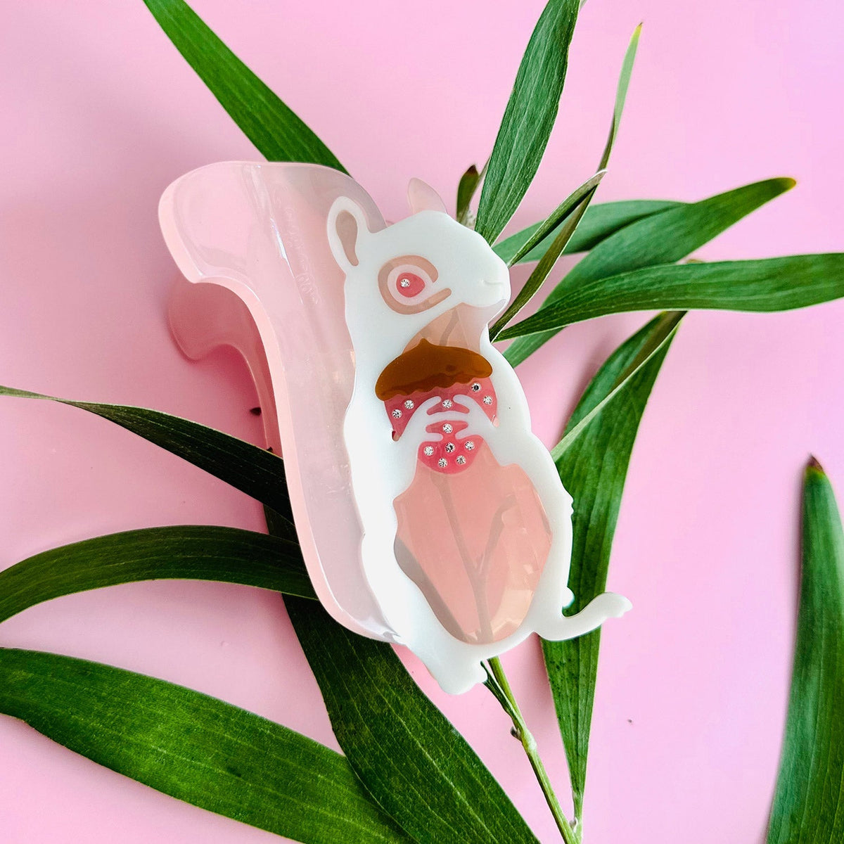 Squirrel-shaped pink translucent hair claw with white body and detailed face